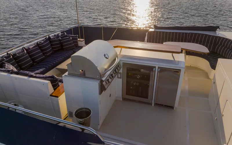 Slide: The Image of Luxurious 2003 Marlow 72C yacht deck with outdoor kitchen and seating area at sunset. - 23