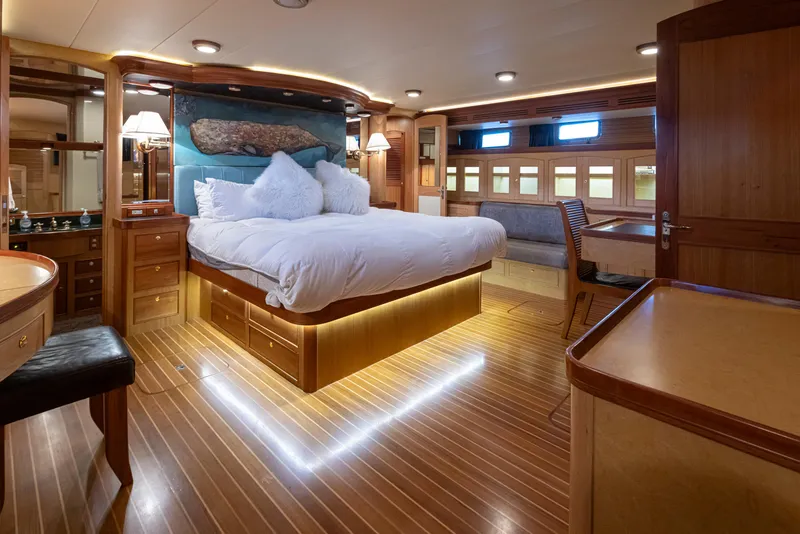 Slide: The Image of Luxurious Marlow 72C yacht bedroom with elegant wood finishes, ambient lighting, and plush bedding. - 38