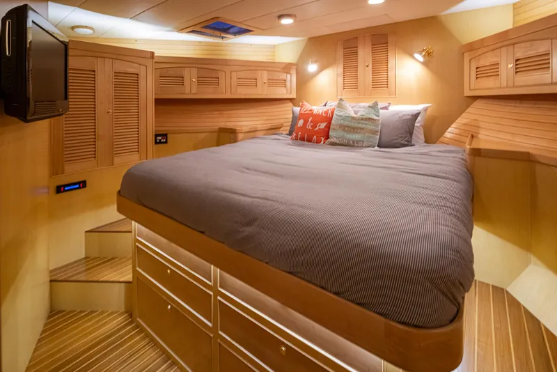 Slide: The Image of Luxurious cabin interior of 2003 Marlow 72C yacht with cozy bed and wooden finishes. - 49