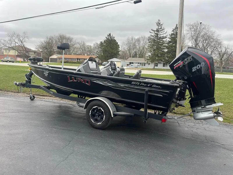 Slide: The Image of 2019 Lund 1875 Pro-V Bass XS boat on trailer, parked outdoors. - 2