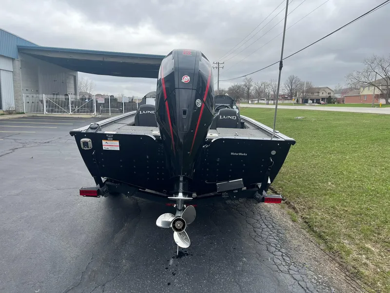 Slide: The Image of 2019 Lund 1875 Pro-V Bass XS boat with outboard motor, parked on pavement. - 3