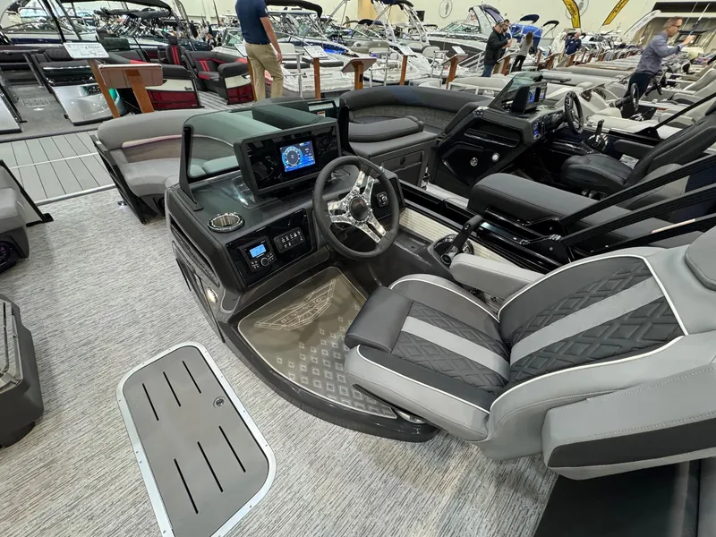 Slide: The Image of 2025 Bennington 22 MFB boat interior with modern dashboard and seating at a showroom. - 13