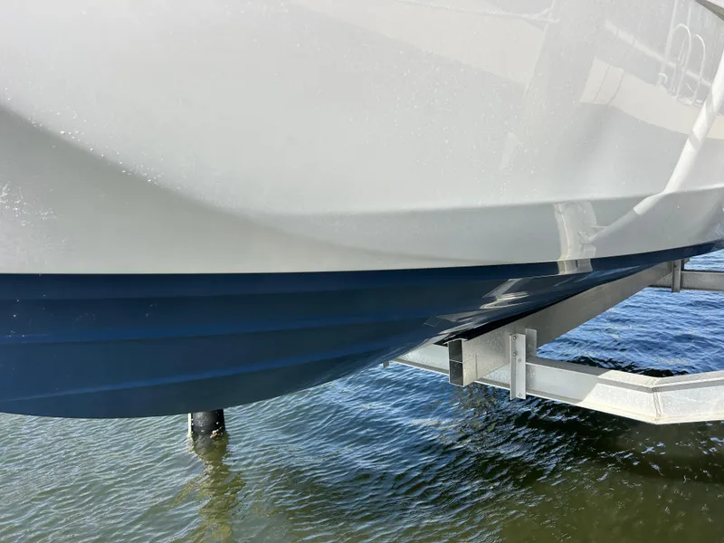 Slide: The Image of 2023 Yamaha Boats 252SD hull on trailer above water. - 12