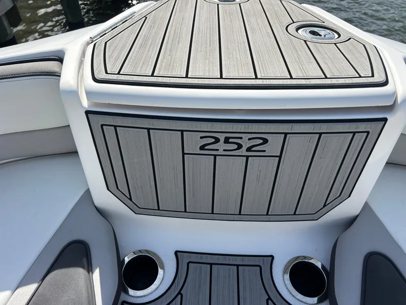 Slide: The Image of 2023 Yamaha Boats 252SD deck with sleek wood finish and cup holders. - 13