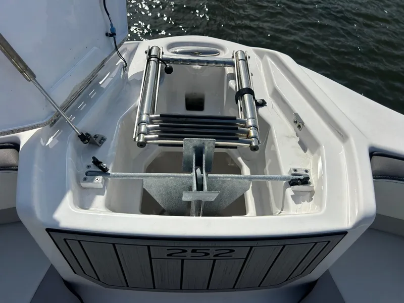 Slide: The Image of 2023 Yamaha Boats 252SD anchor compartment with ladder, open on water. - 14