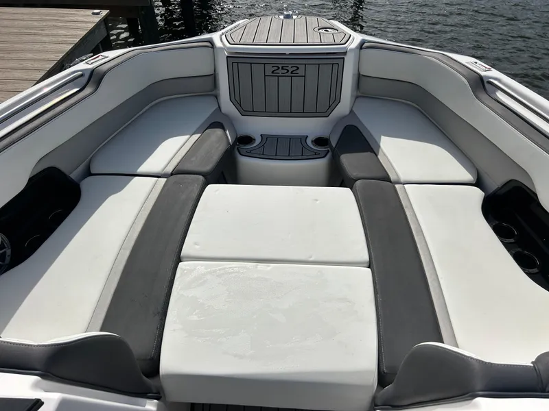 Slide: The Image of 2023 Yamaha Boats 252SD interior seating area with gray and white upholstery. - 18