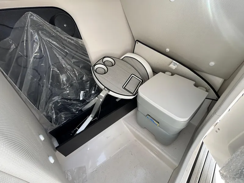 Slide: The Image of 2023 Yamaha Boats 252SD interior with portable toilet and compact table setup. - 22