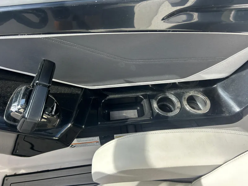 Slide: The Image of 2023 Yamaha Boats 252SD interior with throttle control and cup holders. - 30