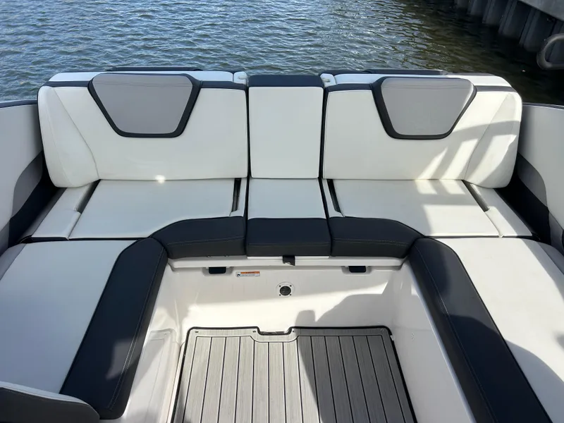 Slide: The Image of 2023 Yamaha Boats 252SD interior seating with sleek design on water. - 35