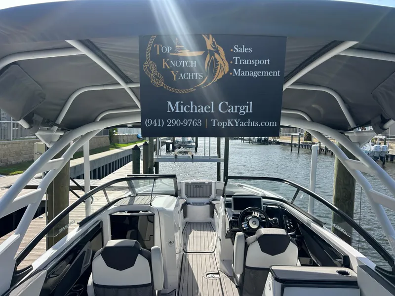 Slide: The Image of 2023 Yamaha Boats 252SD at dock, featuring sleek interior and canopy, Top Knotch Yachts sign visible. - 39