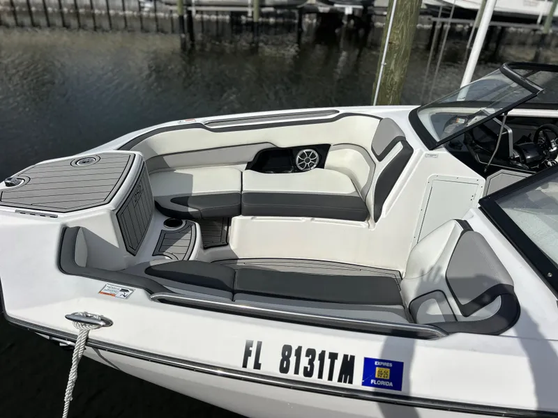 Slide: The Image of 2023 Yamaha Boats 252SD with sleek seating, docked in a marina. - 4