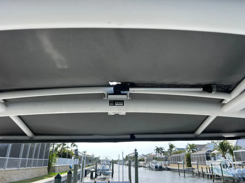 Slide: The Image of 2023 Yamaha Boats 252SD canopy view with waterfront background. - 40