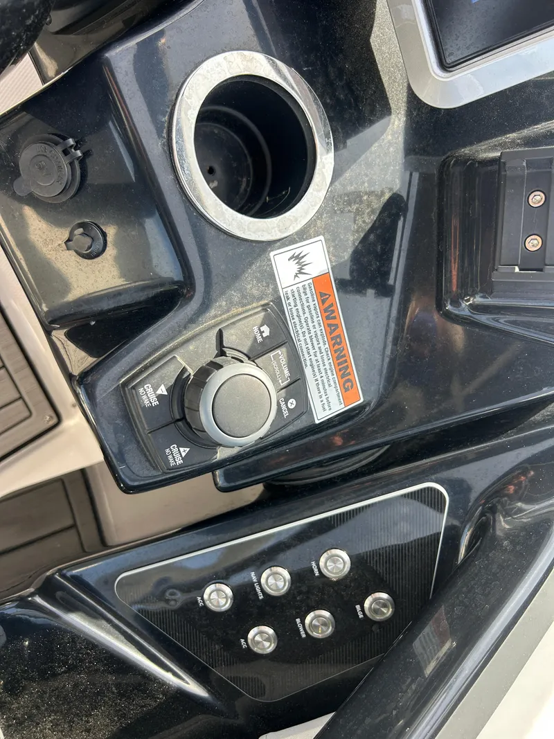 Slide: The Image of Control panel of 2023 Yamaha Boats 252SD with warning label and switches. - 46