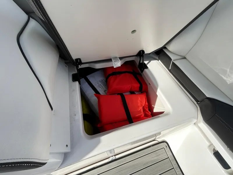Slide: The Image of 2023 Yamaha Boats 252SD storage compartment with life jackets. - 48
