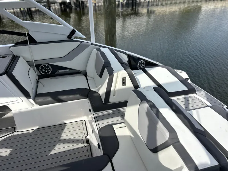 Slide: The Image of 2023 Yamaha Boats 252SD interior with sleek seating and modern design by the water. - 6