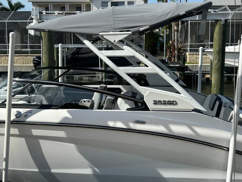 Slide: The Image of 2023 Yamaha Boats 252SD with canopy, docked in a marina setting. - 7