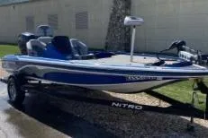 Slide: The Image of 2019 Nitro Z18 boat on trailer, blue and white design, parked outdoors. - 0