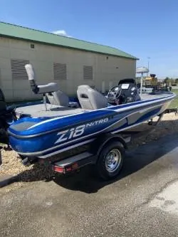 Slide: The Image of 2019 Nitro Z18 boat with blue and white design parked outdoors. - 1