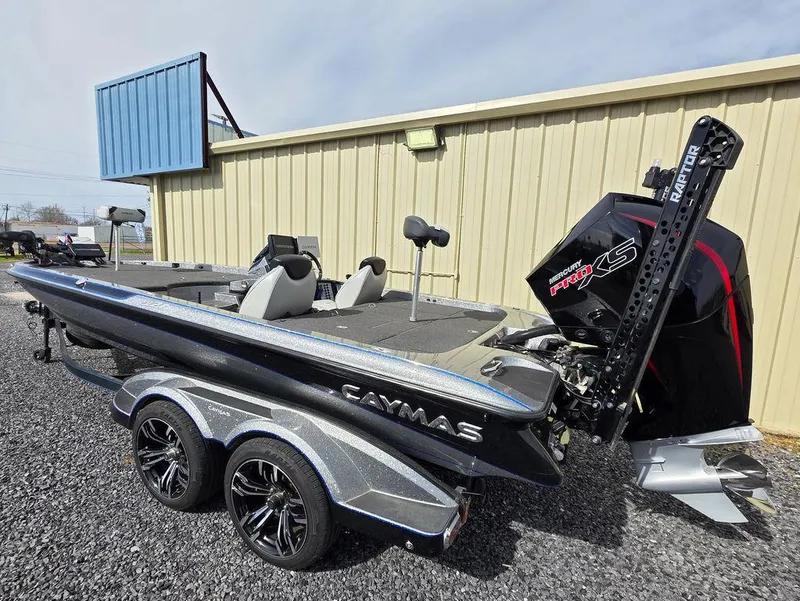 Slide: The Image of 2021 Caymas CX 21 boat with trailer, parked outdoors, featuring a powerful engine. - 3
