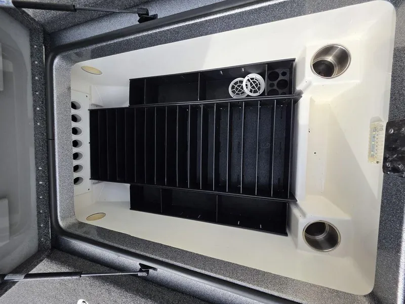 Slide: The Image of 2021 Caymas CX 21 boat storage compartment with organized tackle trays and cup holders. - 40