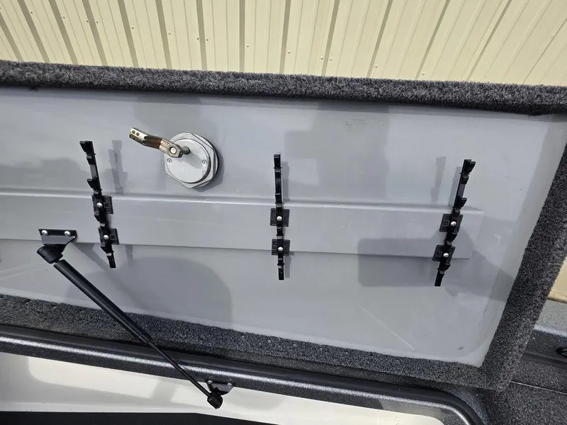Slide: The Image of 2021 Caymas CX 21 boat storage compartment with rod holders and latch mechanism. - 43