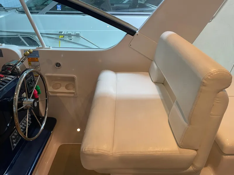 Slide: The Image of 2002 Tiara Yachts 3500 Open helm with white seating and steering wheel. - 12