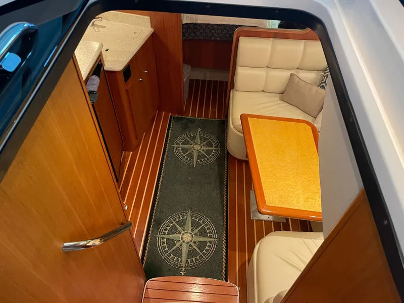 Slide: The Image of Interior of 2002 Tiara Yachts 3500 Open with wood flooring and cozy seating area. - 16