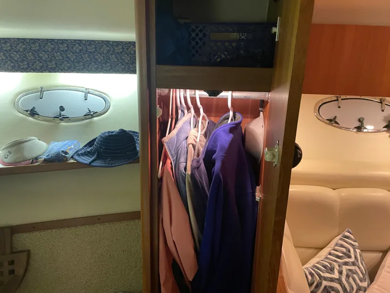 Slide: The Image of 2002 Tiara Yachts 3500 Open interior closet with clothes and hats. - 21