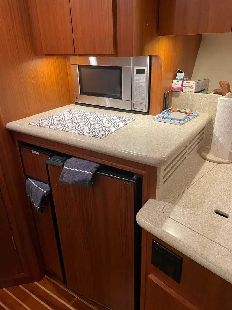 Slide: The Image of 2002 Tiara Yachts 3500 Open galley with microwave, wooden cabinets, and countertop. - 23