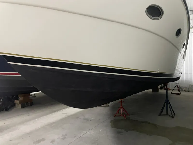 Slide: The Image of 2002 Tiara Yachts 3500 Open boat hull in storage, supported by stands. - 35