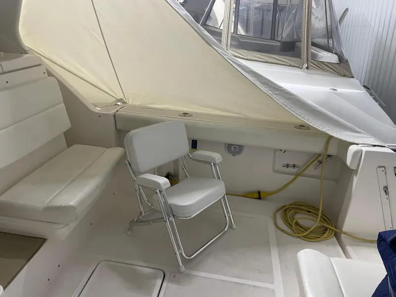 Slide: The Image of 2002 Tiara Yachts 3500 Open interior with white seating and a folding chair. - 6
