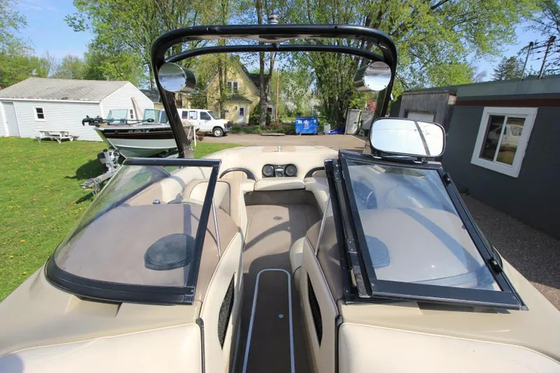 Slide: The Image of 2007 Malibu Wakesetter 23 LSV interior with open windshield, parked in a residential area. - 17