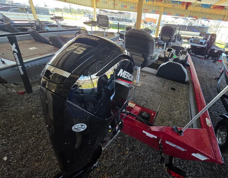 Slide: The Image of 2025 Tracker Pro Team 175 TXW® boat with Mercury engine, parked in a covered area. - 4