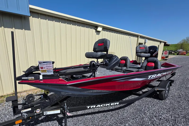 Slide: The Image of 2025 Tracker Pro Team 175 TXW Tournament Edition boat, red, parked on gravel near a building. - 7