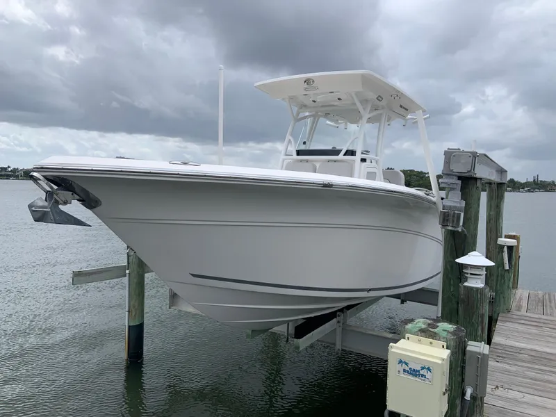 Slide: The Image of 2019 Sea Fox 266 Commander boat docked on a lift under cloudy skies. - 1