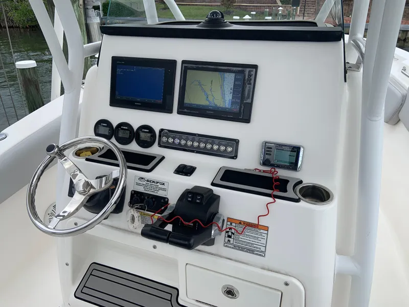 Slide: The Image of Control panel of 2019 Sea Fox 266 Commander boat with navigation screens and steering wheel. - 2