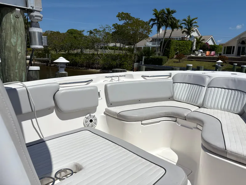 Slide: The Image of 2019 Sea Fox 266 Commander boat with white cushioned seating, docked near waterfront homes. - 20