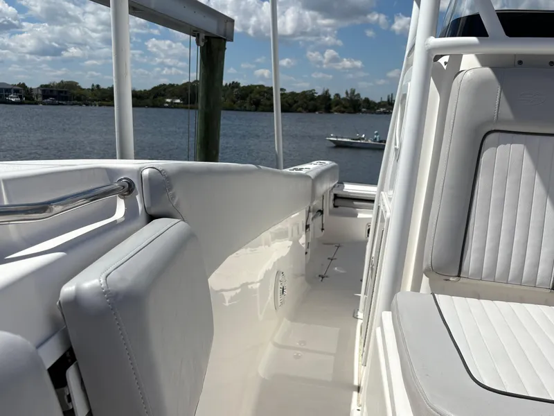 Slide: The Image of 2019 Sea Fox 266 Commander boat interior with white seating, docked by a calm lake. - 22