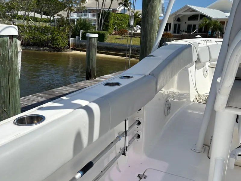 Slide: The Image of 2019 Sea Fox 266 Commander boat interior with rod holders and seating near a dock. - 23
