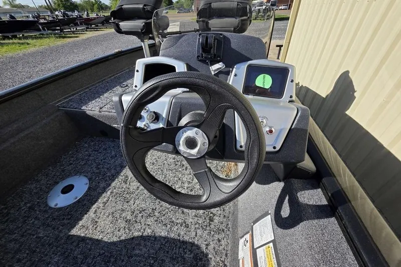 Slide: The Image of 2025 Tracker Pro Team 175 Crappie Edition boat with Mercury engine, parked on gravel. - 4