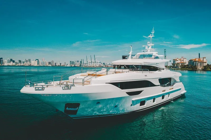Slide: The Image of Luxury Benetti Delfino Co Ownership yacht, 2020 model, cruising in a scenic coastal city backdrop. - 2