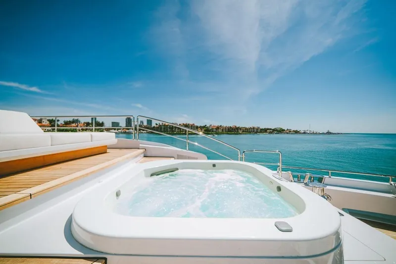 Slide: The Image of Luxurious Benetti Delfino yacht deck with jacuzzi, ocean view, and clear blue sky, 2020 model. - 10