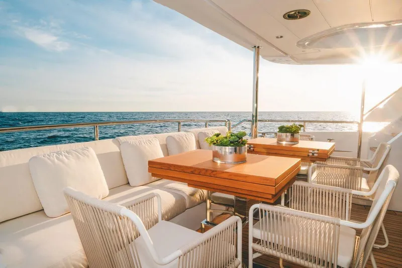 Slide: The Image of Luxurious Benetti Delfino yacht deck with ocean view, featuring elegant seating and tables, 2020 model. - 16