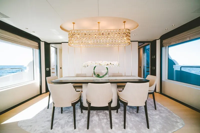 Slide: The Image of Luxurious dining area on 2020 Benetti Delfino Co Ownership yacht with elegant chandelier and ocean view. - 34