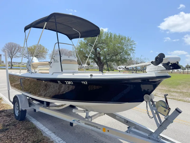 Slide: The Image of 2016 Key West 1720 Center Console boat on trailer, black hull, bimini top, sunny day. - 6