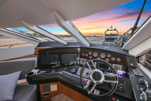 Slide: The Image of 2008 Sunseeker Manhattan 60 yacht helm with sunset view, featuring modern navigation equipment. - 18