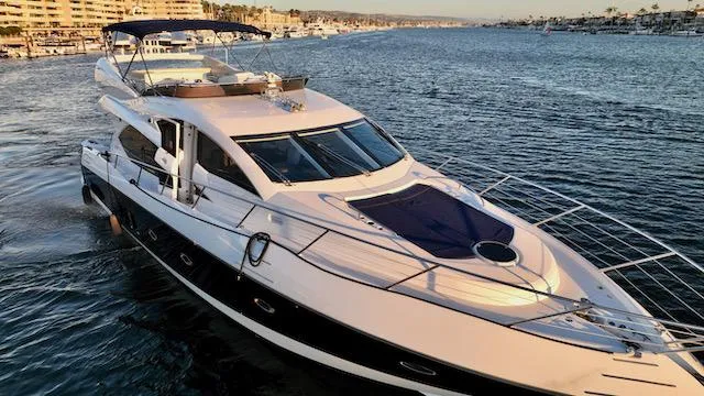 Slide: The Image of 2008 Sunseeker Manhattan 60 yacht cruising in a scenic harbor. - 2