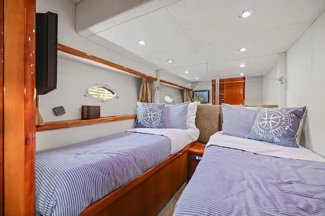 Slide: The Image of Luxurious twin cabin interior of 2008 Sunseeker Manhattan 60 yacht, featuring elegant bedding and wood accents. - 32