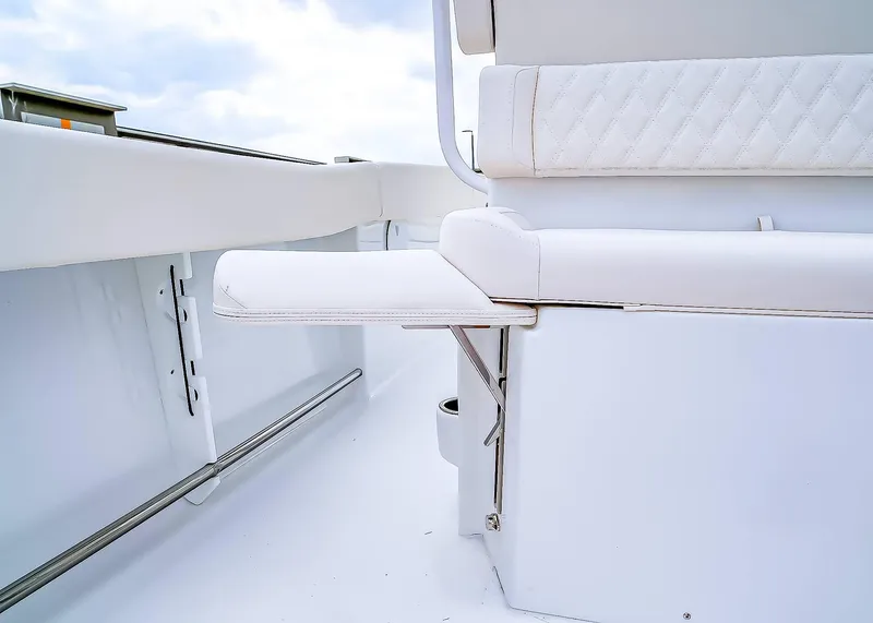 Slide: The Image of 2025 Sea Hunt Ultra 245 SE boat interior with white cushioned seating and stainless steel accents. - 11