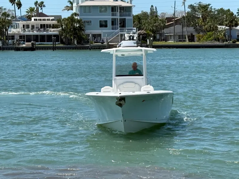 Slide: The Image of 2016 Sea Hunt Gamefish 27 boat cruising on a sunny day near waterfront homes. - 13